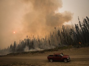 Verne Tom stops to check on a wildfire burning on a logging road approximately 20km southwest of Fort St. James, B.C., on Wednesday, August 15, 2018. The British Columbia government has declared a provincial state of emergency to support the response to the more than 500 wildfires burning across the province.