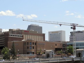 In this photo taken June 4, 2018, a construction crane looms over downtown and the Monroe Street Bridge in Spokane, Wash. The state's second-largest city is booming these days thanks to a good economy and influx of new residents.