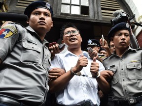 Myanmar journalist Wa Lone (C) is escorted by police after being sentenced by a court to jail in Yangon on September 3, 2018. - Two Reuters journalists were jailed on September 3 for seven years for breaching Myanmar's official secrets act during their reporting of the Rohingya crisis, a judge said, a case that has drawn outrage as an attack on media freedom.