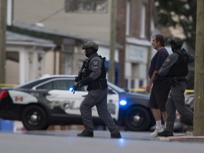 A person is escorted from a building on Queenston Street near the site where a shooting took place in St. Catharines, Ont., Thursday September 6, 2018.