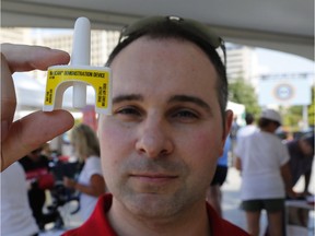 Pharmacy owner Ryan Jarratt holds up a nasal Narcan spray at the "Recovery Day" event at Ottawa City Hall on Saturday. Patrick Doyle/Postmedia