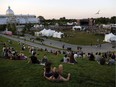 People watch from the vantage point of a grass-covered slope as Whitehorse performs on the last evening of CityFolk at Lansdowne Park on Sunday, Sept. 16, 2018.