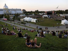 People watch from the vantage point of a grass-covered slope as Whitehorse performs on the last evening of CityFolk at Lansdowne Park on Sunday, Sept. 16, 2018.