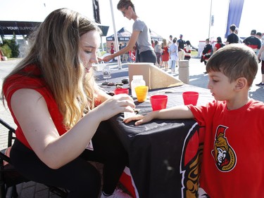 Hussein, 3, gets a sticker placed on his hand at the Ottawa Senators Fan Fest at Canadian Tire Centre in Ottawa on Sunday, September 16, 2018.