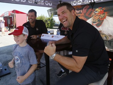 Leyland, 11, poses for a photo with retired Ottawa Senators Patrick Lalime, left, and Andre Roy at the Ottawa Senators Fan Fest at Canadian Tire Centre in Ottawa on Sunday, September 16, 2018.