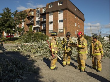 Gatineau Fire officials walk along Rue Étienne-Brule in the Mont-Bleu community in Gatineau, which is in clean-up mode Saturday, September 22, 2018 after a tornado touched down late Friday.