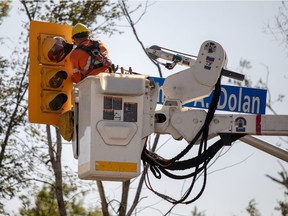 A City of Ottawa worker fixes a traffic light in Dunrobin on Monday. Darren Brown/Postmedia