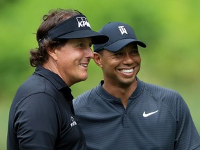 Phil Mickelson (L) and Tiger Woods smile during a practice round prior to the World Golf Championships-Bridgestone Invitational at Firestone Country Club South Course on August 1, 2018 in Akron, Ohio.