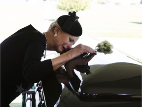In this photo courtesy of the McCain Family, Cindy McCain lays her head on the casket of Sen. John McCain, R-Ariz., during a burial service at the cemetery at the United States Naval Academy on the weekend.
