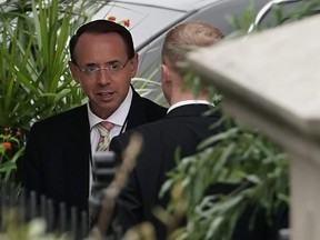 U.S. Deputy Attorney General Rod Rosenstein talks to an unidentified man as he arrives at the White House September 27, 2018 in Washington, DC.
