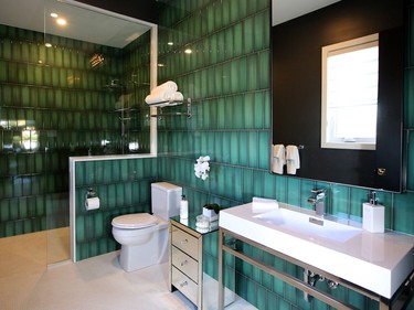 The fully accessible ensuite in the in-law suite pops with bright green tile. Green is a recurring colour throughout the home, suggesting the natural backdrop of the home's location. Julie Oliver/Postmedia