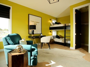 The boy's room is aimed at a teenager, with a fun but toned-down chartreuse on the walls, black accents for a masculine feel and over-sized double bunkbeds. Julie Oliver/Postmedia