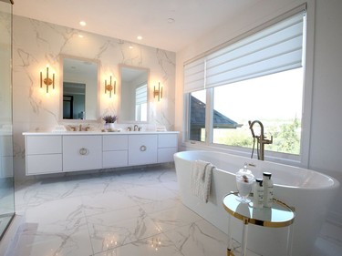 A Maxx Louie soaker tub beckons in the master ensuite, which is bathed in shades of white and gold for a calm and luxurious feel. It has the look of marble, but is done in a more affordable ceramic tile. Julie Oliver/Postmedia