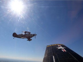 Brent Handy flies a red Pitt Special plane alongside the T28C Trojan flown by Alfred Beam over the Gatineau Hills on Friday. Jean Levac/Postmedia