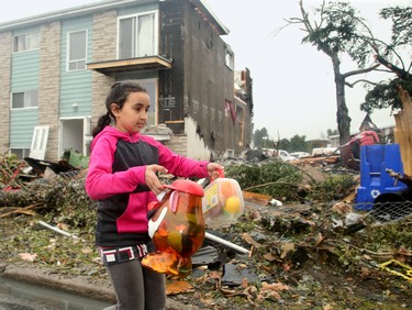 - Nine-year-old Emna Ben-Salem carries out some of the toys she could find in her bedroom of her family's home (rear), which will more than likely be demolished as half the roof and side on the triplex was ripped off in the tornado. The family car sits upended under a tree (at right). Demolition started in the Mont-Bleu area of Gatineau Tuesday following the tornado that ripped through the housing development Friday. People could be found gathering up what little they could find in the remains of their homes as crews worked to demolish unsafe buildings and clean up debris.  Julie Oliver/Postmedia