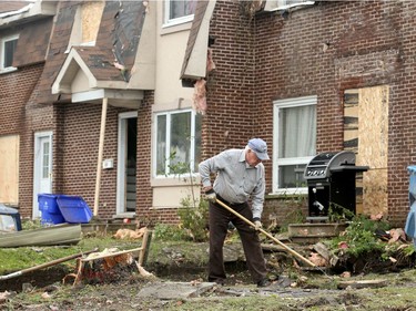 87-year-old, Douglas Smith rakes up debris from the front lawn of a row of townhomes he built with his brother back in 1969. "They'll stand," he said. "Just need a bit of work." Demolition and cleanup continued Wednesday in the Mont-Bleu area of Gatineau as residents hard hit by last Friday's tornado salvaged what they could from their homes and workers started repairing roofs, continued hydro line repairs and clearing trees and debris.