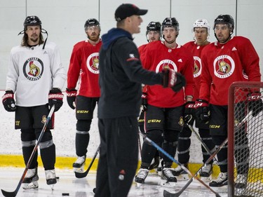 Ottawa Senators captain Erik Karlsson (L) and teammates listen to development coach Sean Donovan during an informal pre-training camp skate at the Bell Sensplex. September 11, 2018. Errol McGihon/Postmedia
