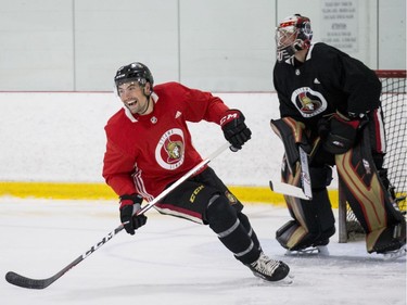 Ottawa Senators Cody Ceci smiles as he skates past goaltender Craig Anderson during an informal pre-training camp skate at the Bell Sensplex. September 11, 2018. Errol McGihon/Postmedia