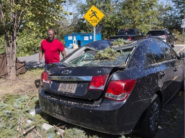 Tristan Alleyne checks storm damage to his car at the Quarry Co-op on McCarthy Road in Ottawa. September 22, 2018.