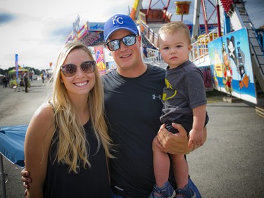 Guillame Poirier, holding 14-month-old Eliam Poirier, with Karolann Poirier checking out the midway.