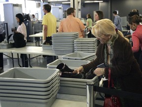 An air traveler places some of her belongings into a bin at a security checkpoint September 25, 2006 at O'Hare International Airport in Chicago, Illinois.