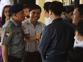 Reuters journalist Kyaw Soe Oo (C) arrives in court in Yangon on September 3, 2018 to face verdict after months of trial since he was detained on December 12, 2017. - Two Reuters journalists Wa Lone, 32, and Kyaw Soe Oo, 28, accused of breaching Myanmar's state secrets law during their reporting of a massacre of Rohingya face a court ruling on September 3, could see them jailed for up to 14 years.