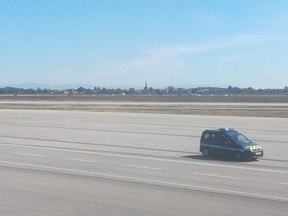 This picture taken with a mobile phone through the window of a plane shows a French gendarmes vehicle speeding on the tarmac of Lyon's Saint-Exupery airport on September 10, 2018.