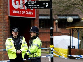 In this file photo taken on March 12, 2018 police officers stand on duty at a cordon near a bench covered in a protective tent at The Maltings shopping centre in Salisbury.