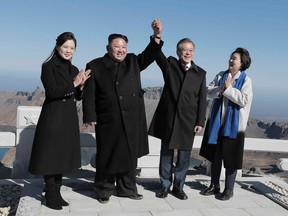 TOPSHOT - North Korean leader Kim Jong Un (2nd L) and his wife Ri Sol Ju (L) pose with South Korean President Moon Jae-in (2nd R) and his wife Kim Jung-sook (R) on the top of Mount Paektu on September 20, 2018. - Kim Jong Un and Moon Jae-in visited the spiritual birthplace of the Korean nation on September 20, for a show of unity after their North-South summit gave new momentum to Pyongyang's negotiations with Washington.