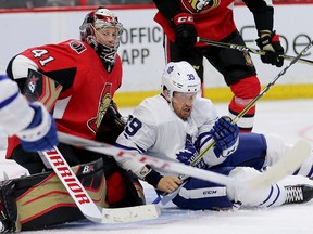 Maple Leafs forward Rich Clune (right) is upended in front of Senators goalie Craig Anderson during the second period on Wednesday night. (Wayne Cuddington/ Postmedia Network)