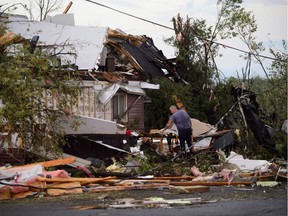 People collect personal effects from damaged homes following a tornado in Dunrobin, Ontario west of Ottawa on Friday, Sept. 21, 2018. A tornado damaged cars in Gatineau, Quebec, and houses in a community west of Ottawa on Friday afternoon as much of southern Ontario saw severe thunderstorms and high wind gusts, Environment Canada said
