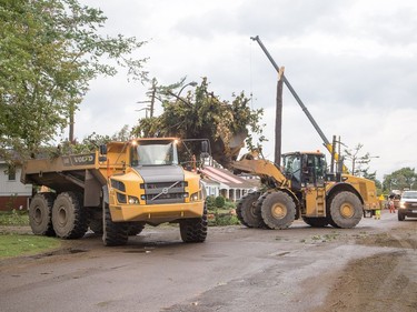 Massive loaders and dump trucks, usually located at Trail Road facility, remove debris from the streets as Arlington Woods continues to be a beehive of activity with arborists, hydro workers and city crews continuing to repair the damage from Friday's tornado.