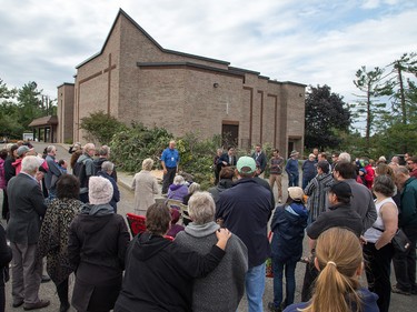 Pastor Mike Hogeboom adresses his congregation outside Arlington Woods First Methodist Church on Sunday morning as residents in Ottawa's Arlington Woods neighbourhood deal with the aftermath of the twister that touched down on Friday afternoon.