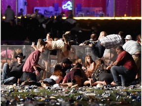 People scramble for shelter at the Route 91 Harvest country music festival after apparent gun fire on October 1, 2017 in Las Vegas, Nevada.