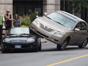 A collision in Hintonburg drew onlookers on Monday, September 3, 2018, when a beige Toyota Camry appeared ended up right on top of a Mazda Miata convertible at Parkdale Avenue and Spencer Street.