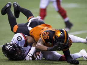 BC Lions defensive back Anthony Orange (26) tackles Ottawa Redblacks wide receiver Diontae Spencer (85) during the first half of CFL football action in Vancouver, B.C., on Friday, Sept. 7, 2018.
