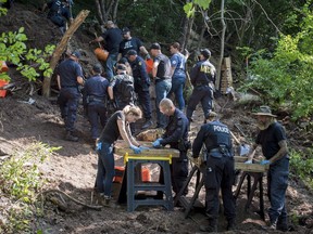 Members of the Toronto Police Service sift and excavate materials from the back of property along Mallory Cres. in Toronto after confirming they have found human remains during an investigation in relation to alleged serial killer Bruce McArthur on Thursday, July 5, 2018. Community members read prayers and sang songs on Saturday at a home in Toronto that's been linked to an alleged serial killer.