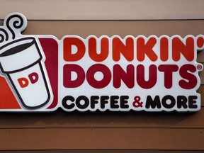 FILE- In this Jan. 22, 2018, file photo shows the Dunkin' Donuts logo on a shop in Mount Lebanon, Pa. Dunkin' is dropping the donuts -- from its name, anyway. Doughnuts are still on the menu, but the company is renaming itself "Dunkin'" to reflect its increasing emphasis on coffee and other drinks.