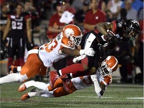 Redblacks receiver R.J. Harris (84) gets pulled down by Lions defenders Jordan Herdman (53) and Winston Rose (25) of during a game in Ottawa on July 20.