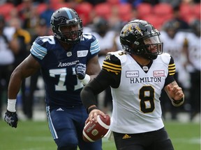 Toronto Argonauts defensive end Rakim Cox (77) chases down Hamilton Tiger-Cats quarterback Jeremiah Masoli (8) .