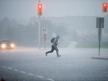 A pedestrian races along March Road as a reported tornado touched down in Dunrobin in the far west end of Ottawa.