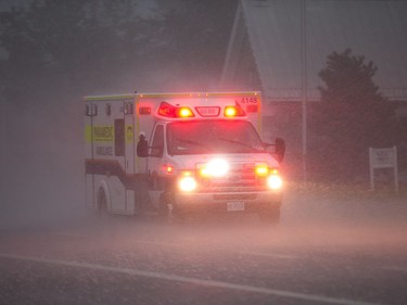 An ambulance races along March Road as a reported tornado touched down in Dunrobin in the far west end of Ottawa. Wayne Cuddington/ Postmedia