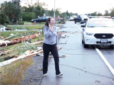 Christy Jarvis outside the home of her cousin before learning that the people inside had been rescued and taken to hospital as a reported tornado touched down in Dunrobin in the far west end of Ottawa. Wayne Cuddington/ Postmedia