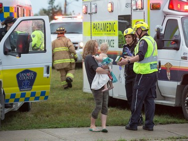 A woman and her baby are tended to by paramedics as a reported tornado touched down in Dunrobin in the far west end of Ottawa. Wayne Cuddington/ Postmedia
