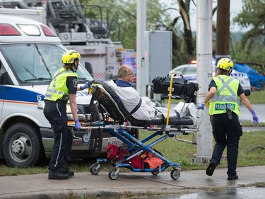 A man is tended to by paramedics as a reported tornado touched down in Dunrobin in the far west end of Ottawa. Wayne Cuddington/ Postmedia