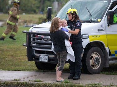 A woman and her baby are tended to by paramedics as a reported tornado touched down in Dunrobin in the far west end of Ottawa. Wayne Cuddington/ Postmedia