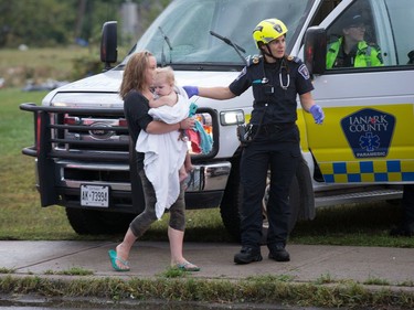 A woman and her baby are tended to by paramedics as a reported tornado touched down in Dunrobin in the far west end of Ottawa. Wayne Cuddington/ Postmedia
