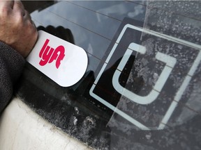 FILE- In this Jan. 31, 2018, file photo, a Lyft logo is installed on a Lyft driver's car next to an Uber sticker in Pittsburgh. The "gig" economy might not be the new frontier for America's workforce after all. From Uber to Lyft to TaskRabbit to YourMechanic, so-called gig work has been widely seen as ideally suited for people who want the flexibility and independence that traditional jobs don't offer. Yet the evidence is growing that over time, they don't deliver the financial returns many expect.