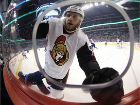 Winnipeg Jets' Joel Armia falls to the ice after hitting Ottawa Senators' Fredrik Claesson.