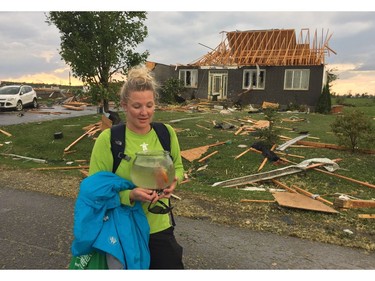 Emily Glossop holds her family's pet fish, Happy, after running through the streets of Dunrobin to see what remained of her family's home late Friday afternoon.  A firefighter retrieved Glossop's backpack, a computer and Happy, who has since been renamed Happy-Go-Lucky.  Photo courtesy of Emily Glossop. For Duffy story